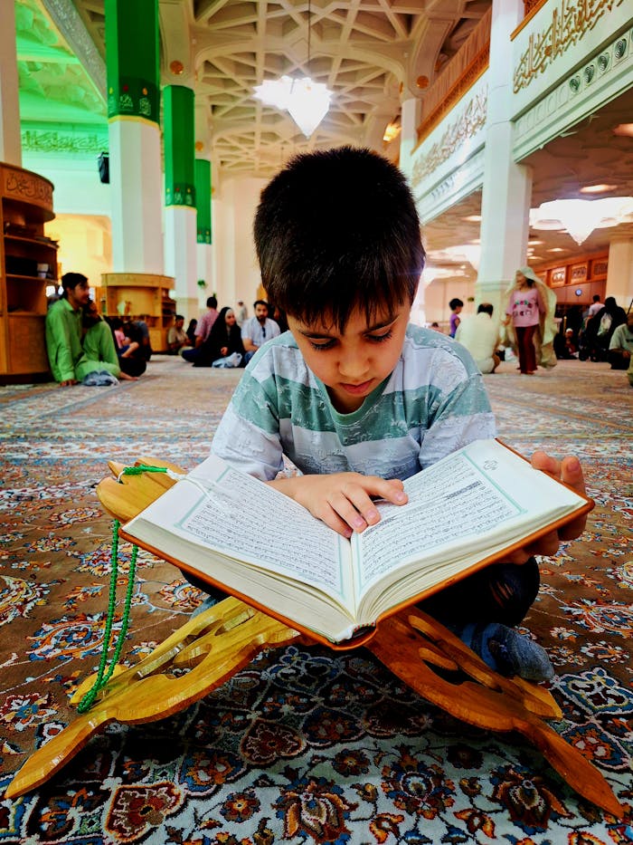 gallery-3 A young boy deeply engrossed in reading the Quran inside a mosque in Qom, Iran.