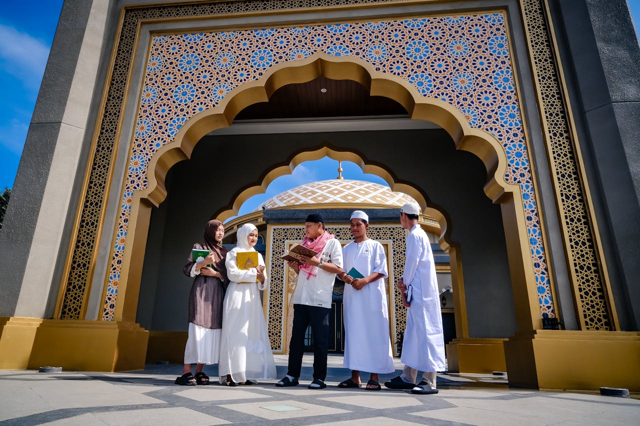 services-01 Diverse group of young Muslims discussing and learning outside a mosque entrance.