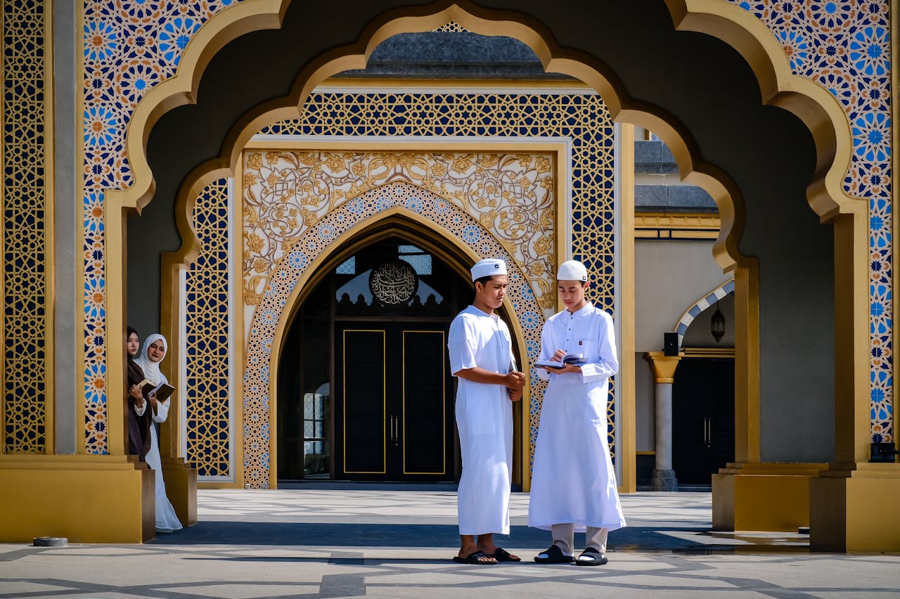 services-03 Group of young Muslims engaged in study at a mosque entrance.